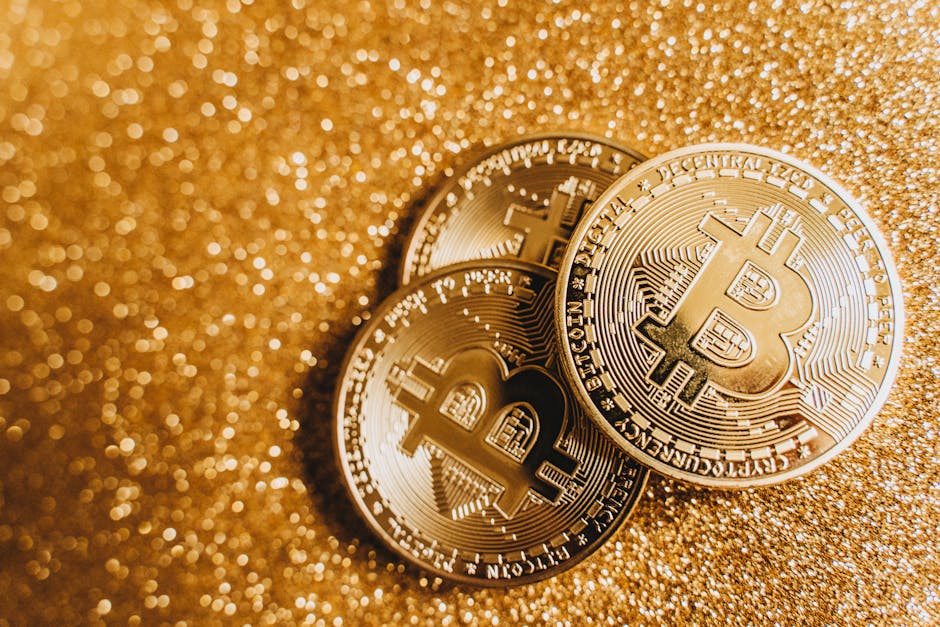 Close-up of three golden Bitcoin coins with a shimmering glittery background, showcasing cryptocurrency elegance.