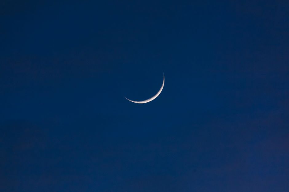 A serene crescent moon set against a deep twilight sky, offering a sense of tranquility and wonder.