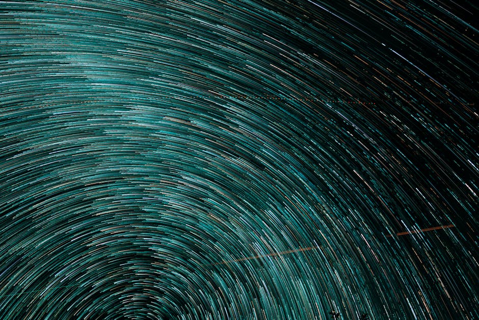 Dynamic turquoise star trails creating a swirling vortex in a captivating abstract pattern.