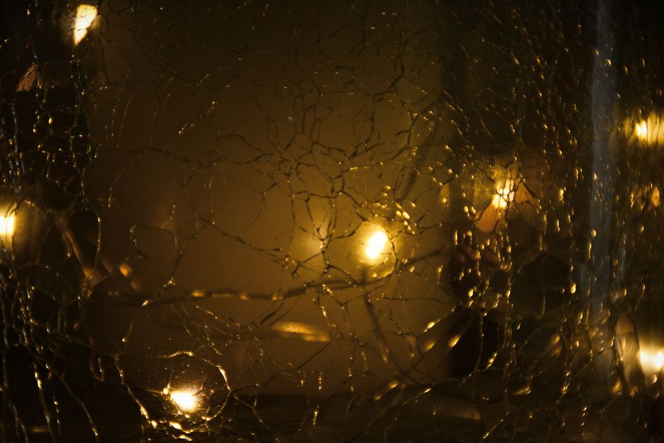 Cracked glass with a warm glow and bokeh effect, creating an abstract design.