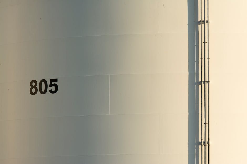 Close-up of a smooth industrial wall with number 805 and vertical pipes.