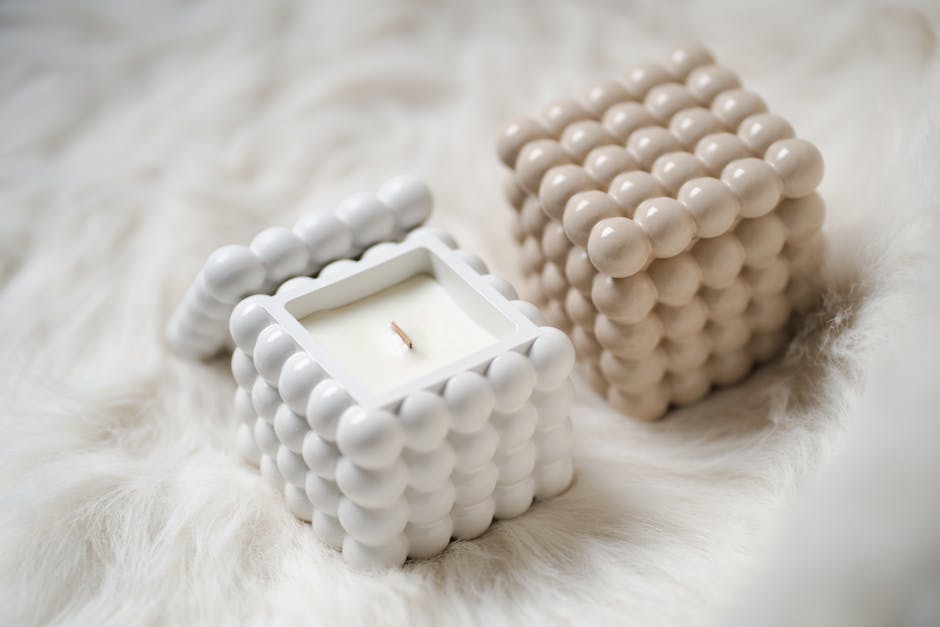 Minimalist ceramic candle holders with a unique design placed on a soft, furry background for cozy home decor inspiration.