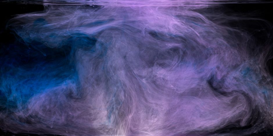 Captivating abstract image of purple and blue smoke swirls against a black background.