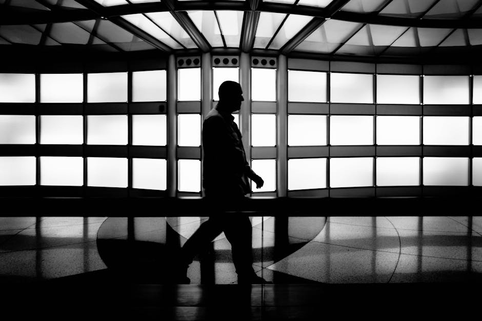 A striking black and white silhouette of a man walking in modern architectural space, Chicago.