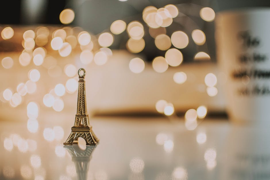 Golden Eiffel Tower miniature with bokeh lights for a festive touch.