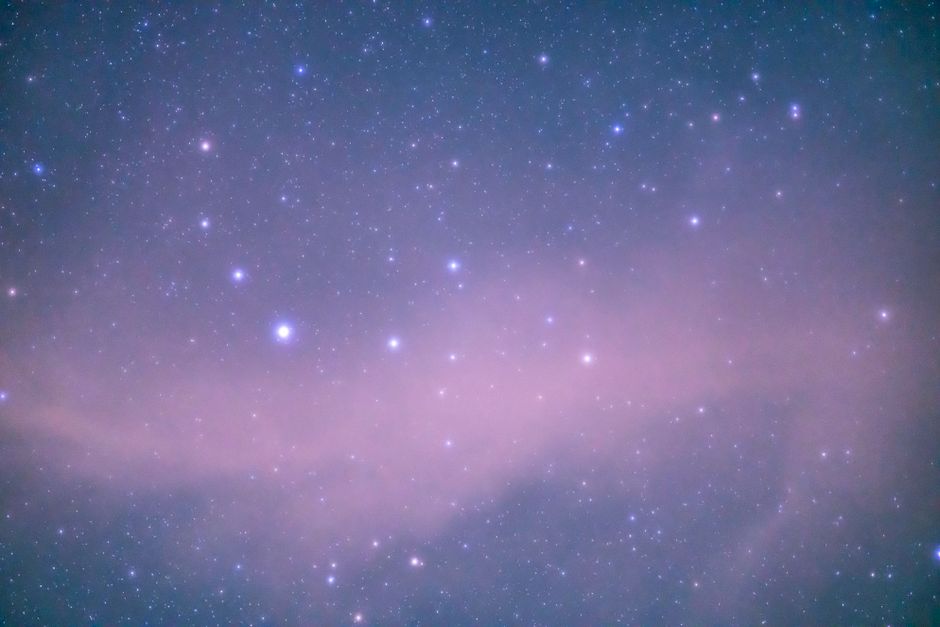 Captivating view of a starry night sky featuring a nebula and constellation.