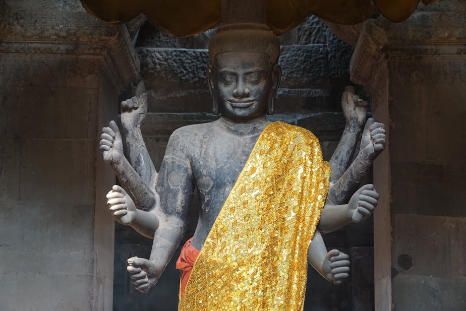 A detailed Vishnu statue draped in gold cloth at Angkor Wat, Cambodia, showcasing Hindu art.