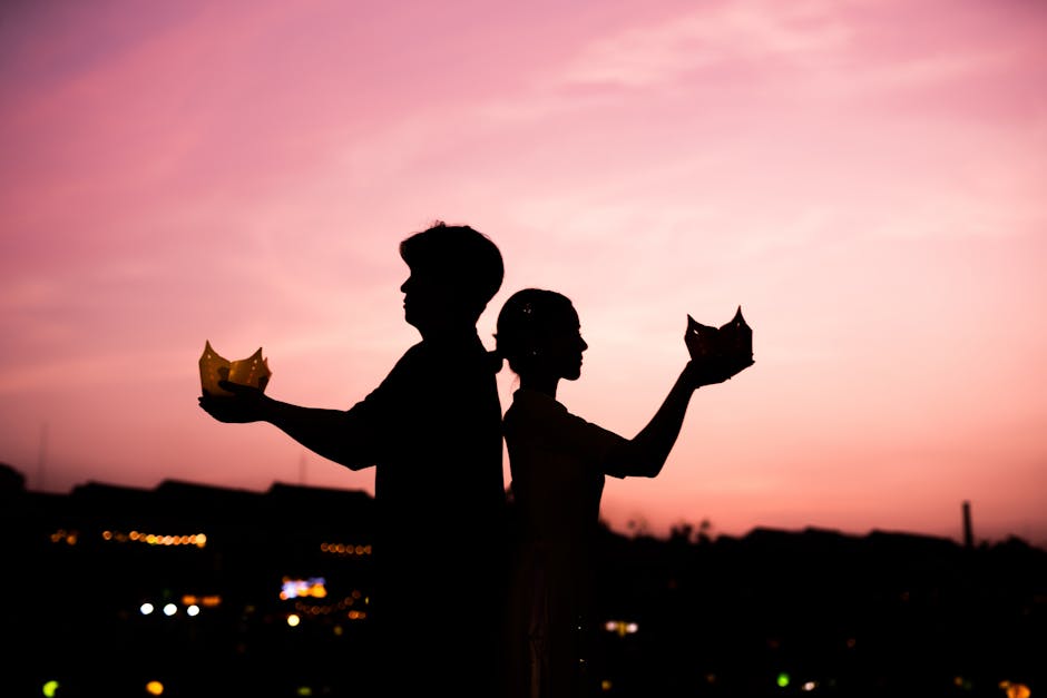 A couple silhouetted against a vibrant sunset, holding traditional lanterns symbolizing love and togetherness.