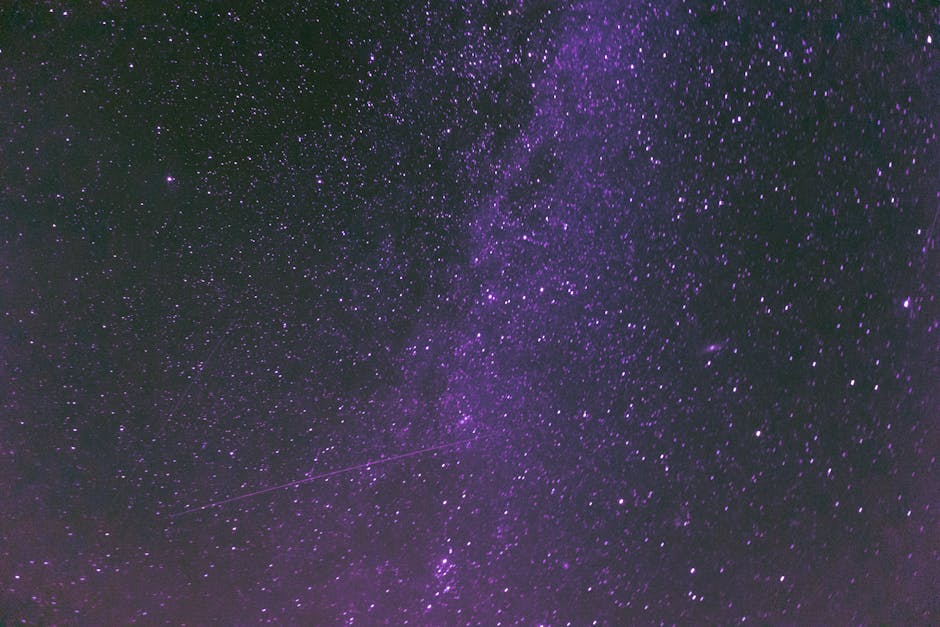 A stunning view of a purple-tinted night sky filled with stars and the Milky Way galaxy.