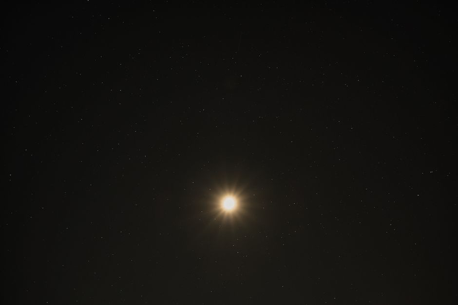 A stunning view of the bright moon surrounded by a starry sky over Poprad, Slovakia.